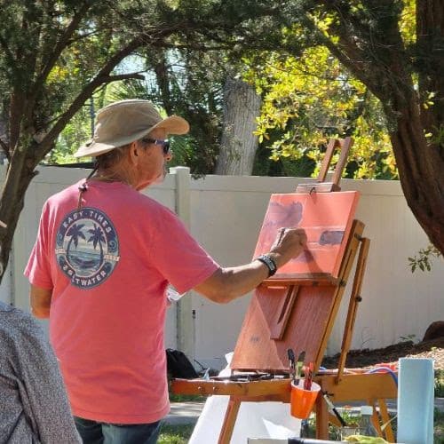 A photograph of a man doing a plein air painting.